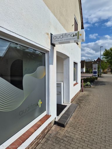 Eingang zu einem modernen Bürogebäude mit Fenster und Beschilderung.